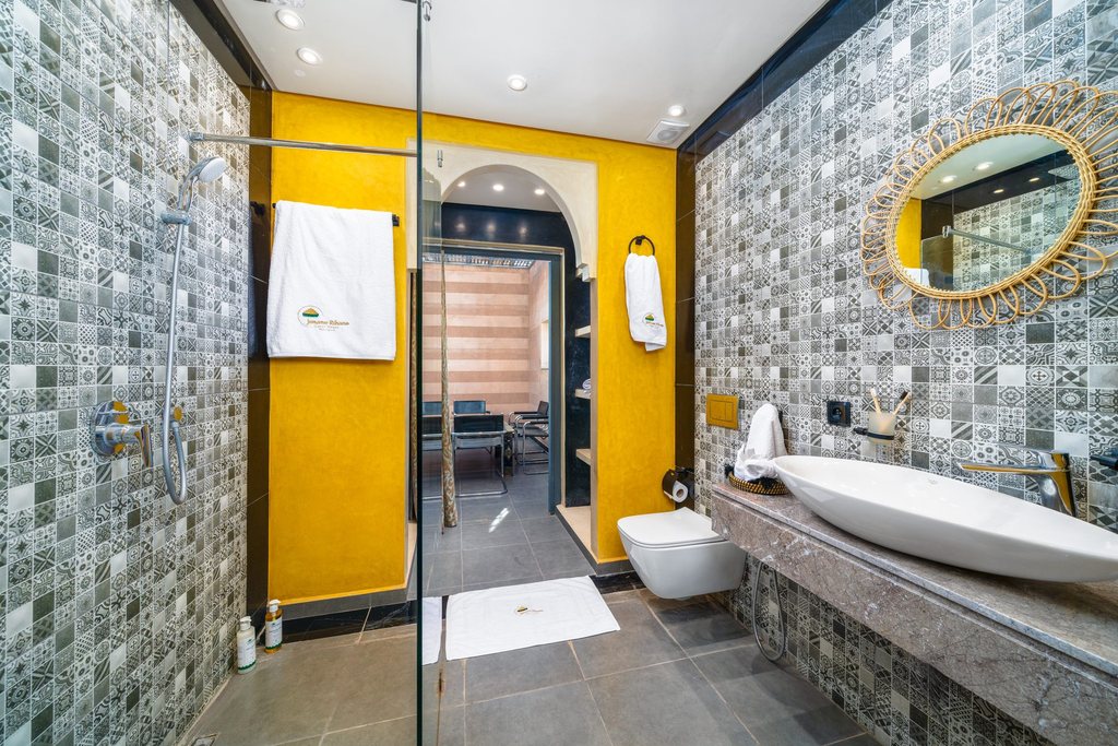 Apartment bathroom with a bathtub and glazed mosaic tiling