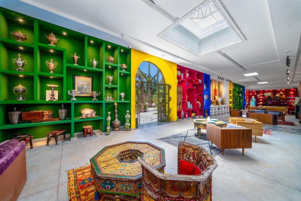 Green and yellow cabinetry filled with collected Moroccan objects