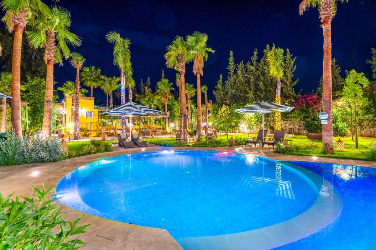 The gardens and pool of Jnane Rihane lit after dark