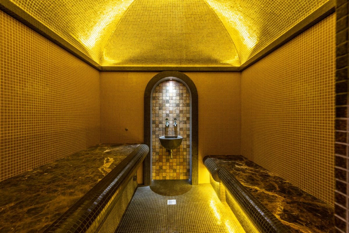 Warm mosaic-tiled hammam interior glowing in golden light