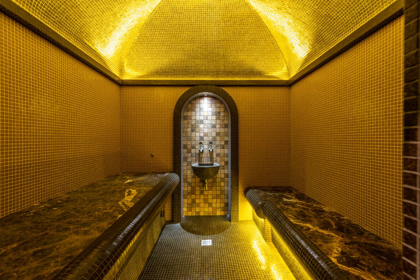Warm mosaic-tiled hammam interior glowing in golden light