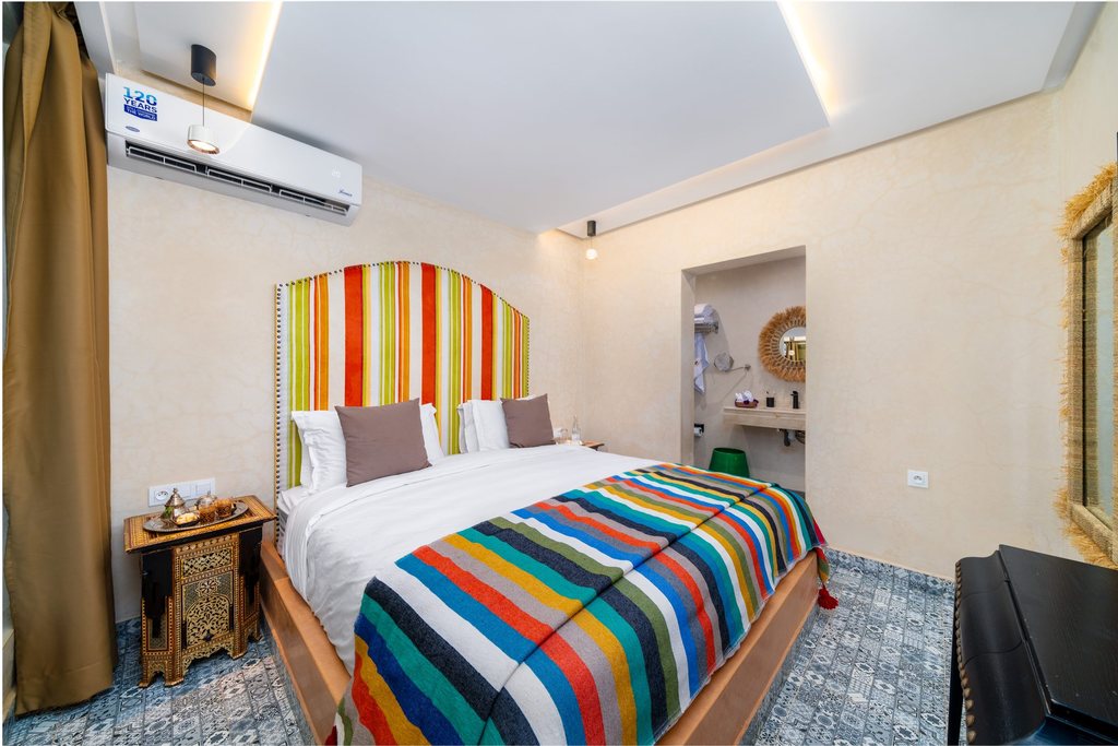 Standard room with a striped headboard and hand-cut zellige floor
