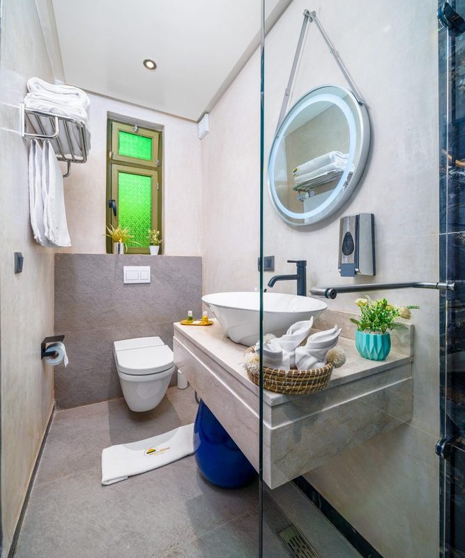 Bathroom vanity with a raffia sunburst mirror in a standard room