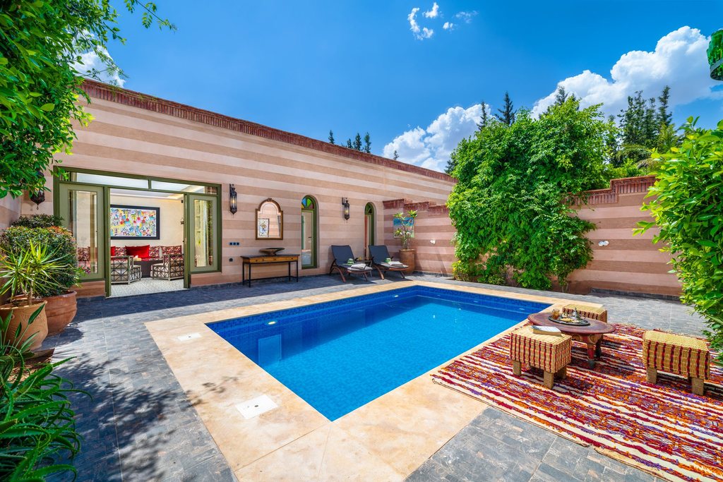 Suite courtyard with loungers, a Berber rug and its private pool