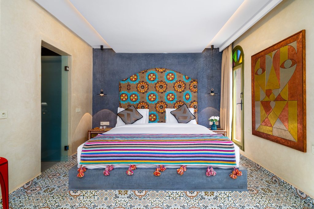 Suite bedroom with a zellige headboard and hand-painted panels