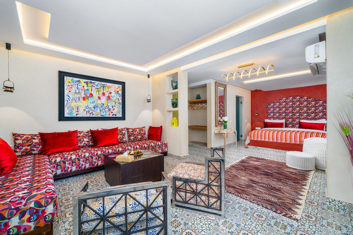 Salon of a suite with red banquettes and a Moroccan low table