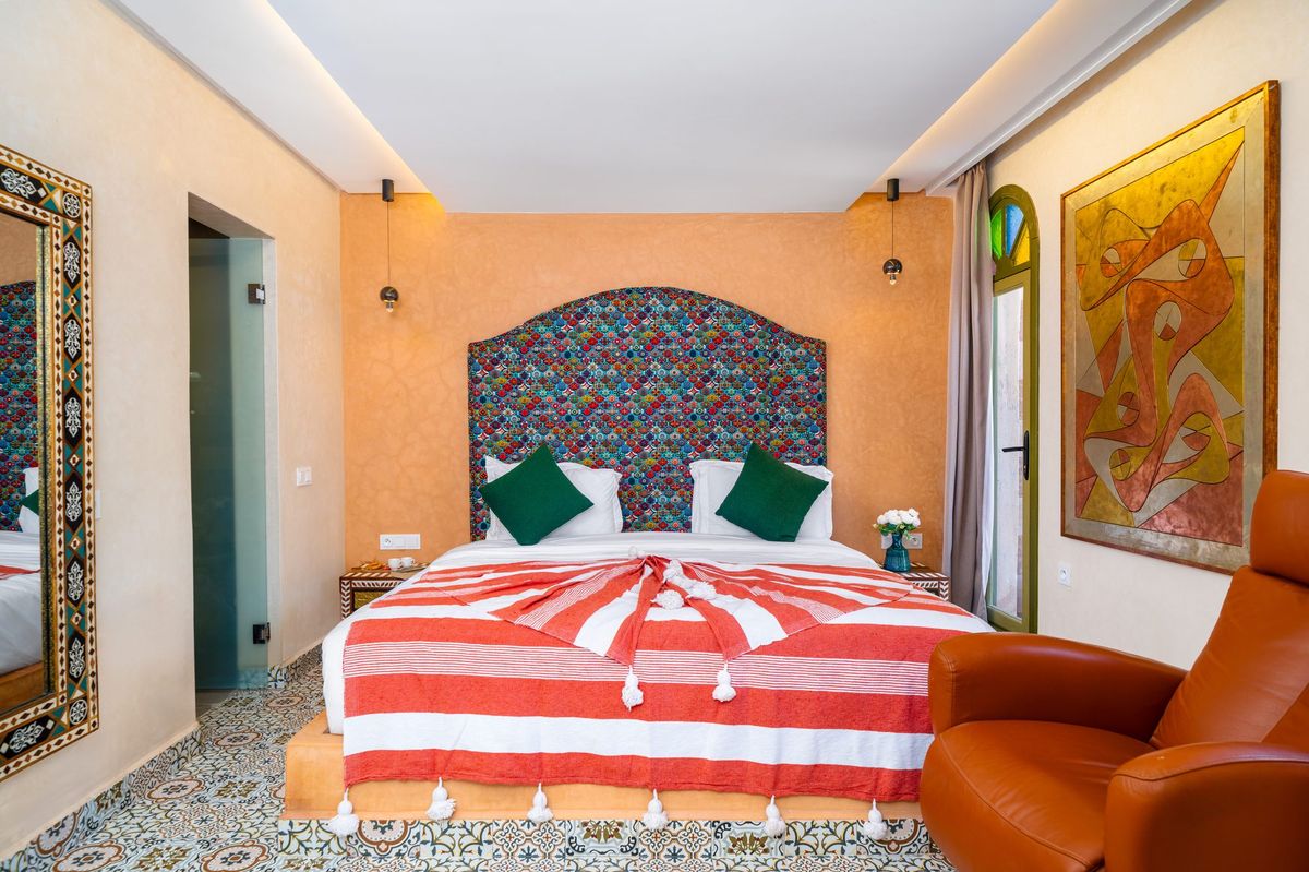 Suite bedroom in warm ochre with a carved headboard alcove