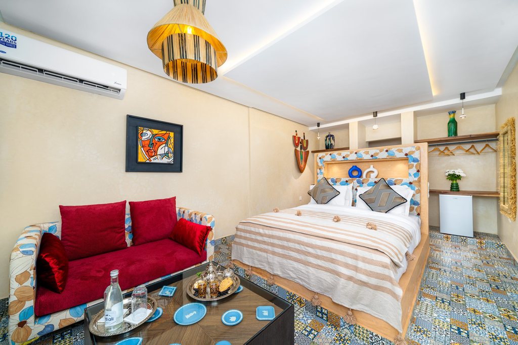 Deluxe room with a crimson sofa and a low brass tea table