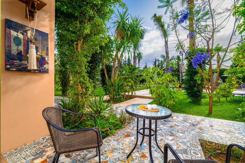 Private terrace of a deluxe room, shaded table beside the lawn