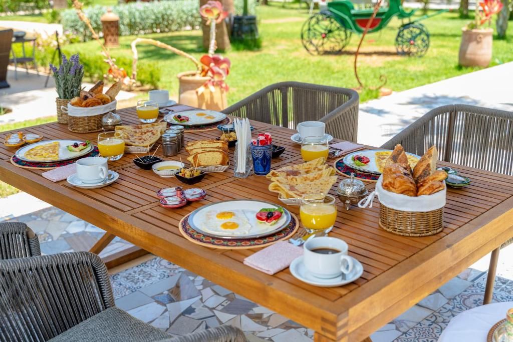 Moroccan breakfast served in the garden with msemen, pastries, eggs and fresh orange juice