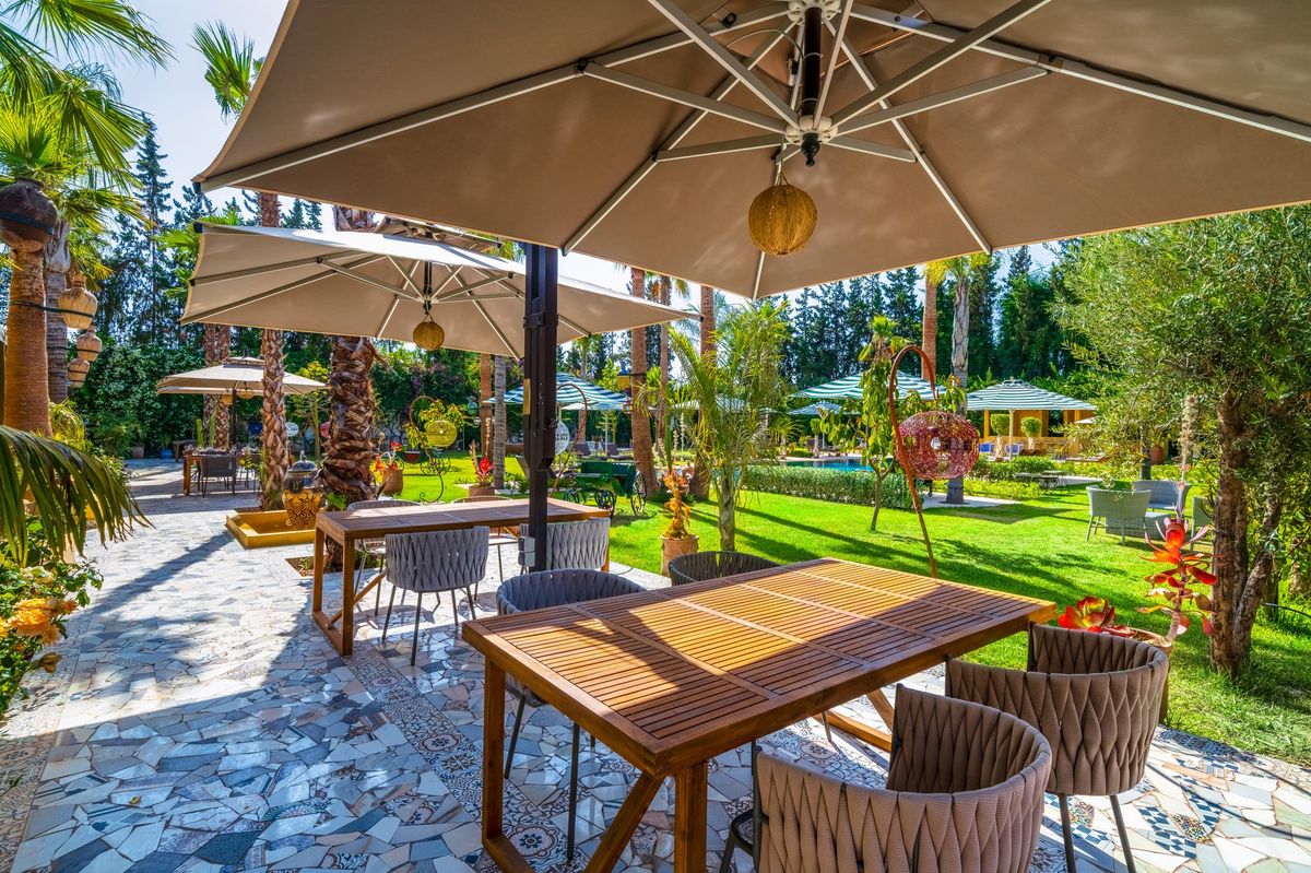 Large table set under a parasol in the gardens of the estate