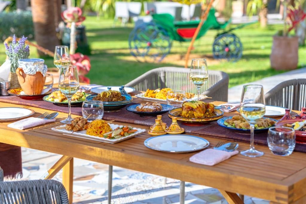 Tagines and Moroccan salads on a long wooden table in the garden